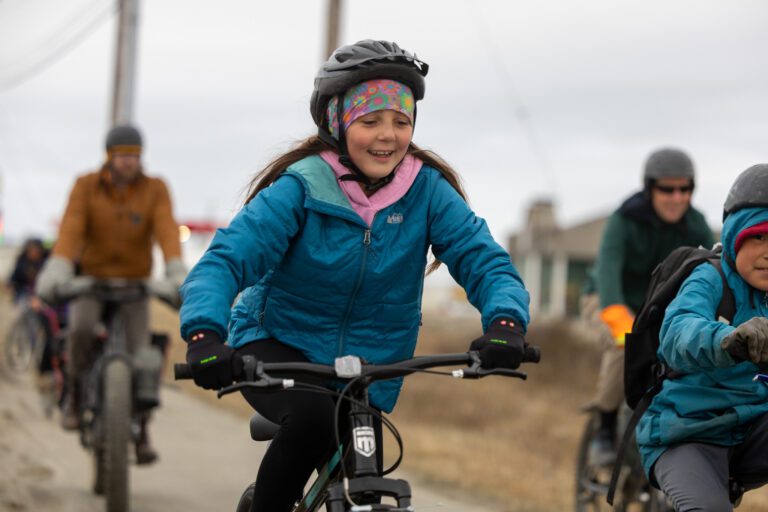 Tessa Timbers-Payenna rides along the bike path parallel to the Nome-Teller Road.