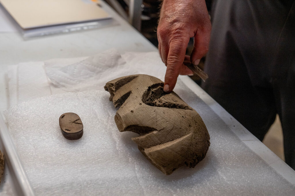 Rick Knecht points out the similarities in design between two artifacts. June 9, 2026.